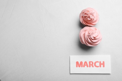8 March greeting card design with cupcakes and space for text on light grey background, flat lay. International Women's day Photo of 8 March greeting card design with cupcakes and space for text on light grey background, flat lay. International Women's day