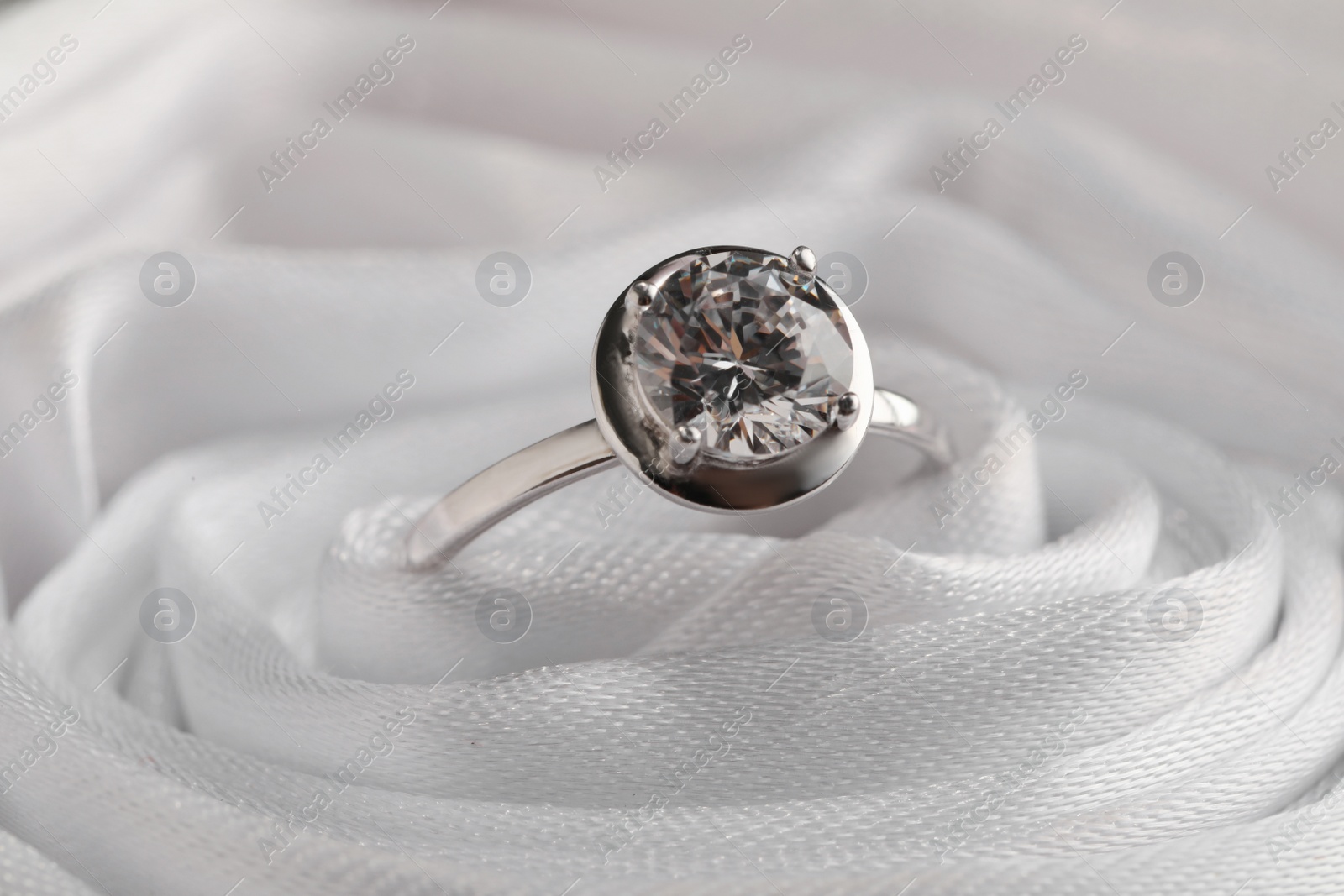 Beautiful engagement ring in white fabric, closeup view Photo of Beautiful engagement ring in white fabric, closeup view