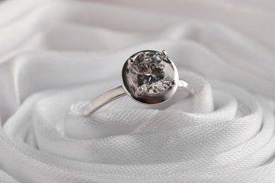 Beautiful engagement ring in white fabric, closeup view Photo of Beautiful engagement ring in white fabric, closeup view