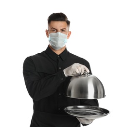 Waiter in medical face mask holding tray with lid on white background Photo of Waiter in medical face mask holding tray with lid on white background