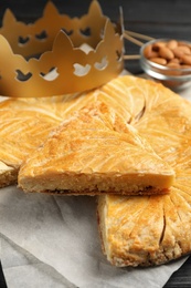 Traditional galette des Rois with paper crown on table, closeup Photo of Traditional galette des Rois with paper crown on table, closeup
