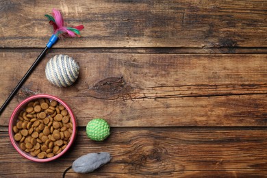 Flat lay composition with different pet toys and feeding bowl on wooden background, space for text Photo of Flat lay composition with different pet toys and feeding bowl on wooden background, space for text