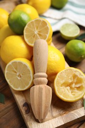 Squeezer with lemons on wooden table, closeup Photo of Squeezer with lemons on wooden table, closeup