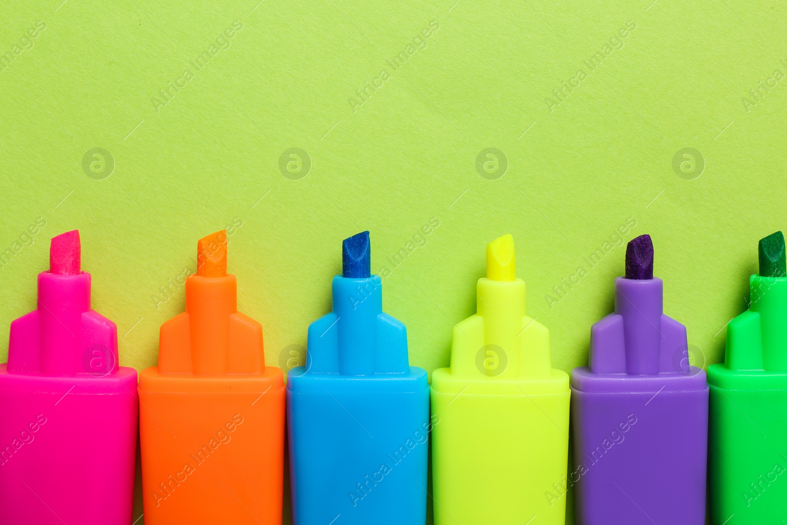 Set of highlighters on light green background, flat lay Photo of Set of highlighters on light green background, flat lay