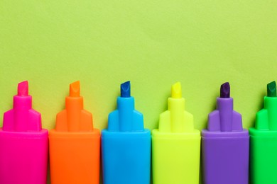 Set of highlighters on light green background, flat lay Photo of Set of highlighters on light green background, flat lay