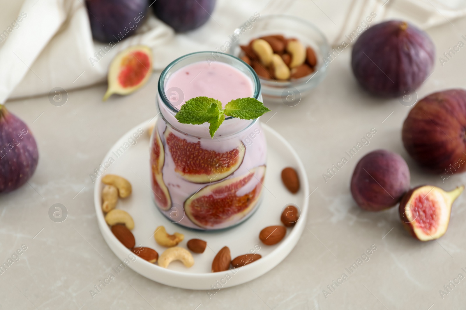Delicious fig smoothie in glass jar on light table Photo of Delicious fig smoothie in glass jar on light table