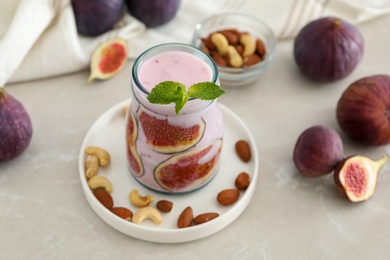 Delicious fig smoothie in glass jar on light table Photo of Delicious fig smoothie in glass jar on light table