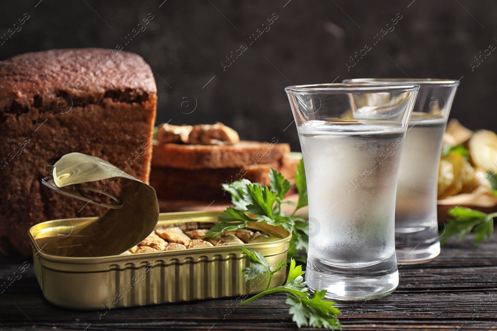 Cold Russian vodka with snacks on black wooden table, closeup Photo of Cold Russian vodka with snacks on black wooden table, closeup