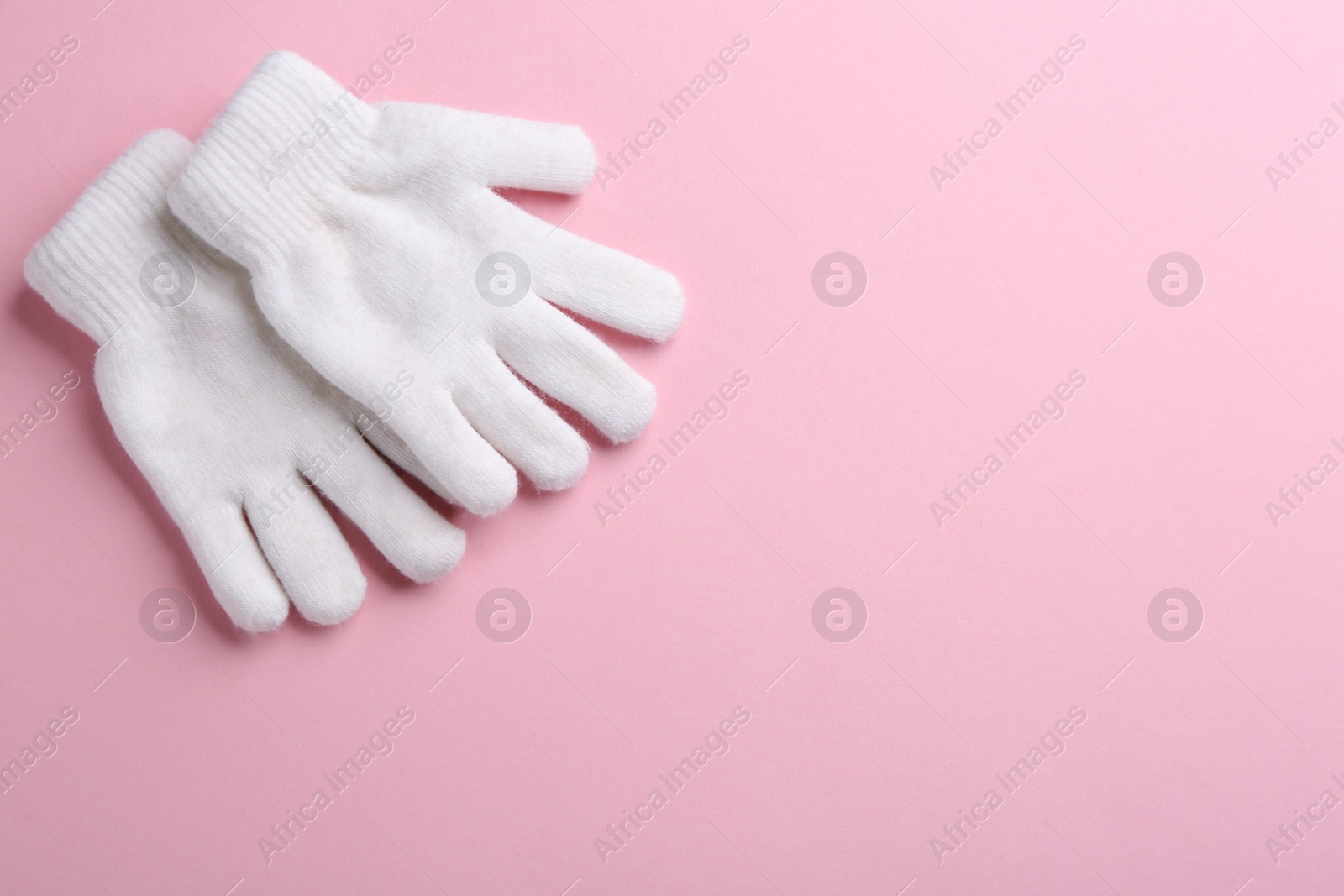 Pair of stylish woolen gloves on pink background, flat lay. Space for text Photo of Pair of stylish woolen gloves on pink background, flat lay. Space for text