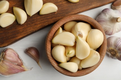Fresh organic garlic on white wooden table, flat lay Photo of Fresh organic garlic on white wooden table, flat lay
