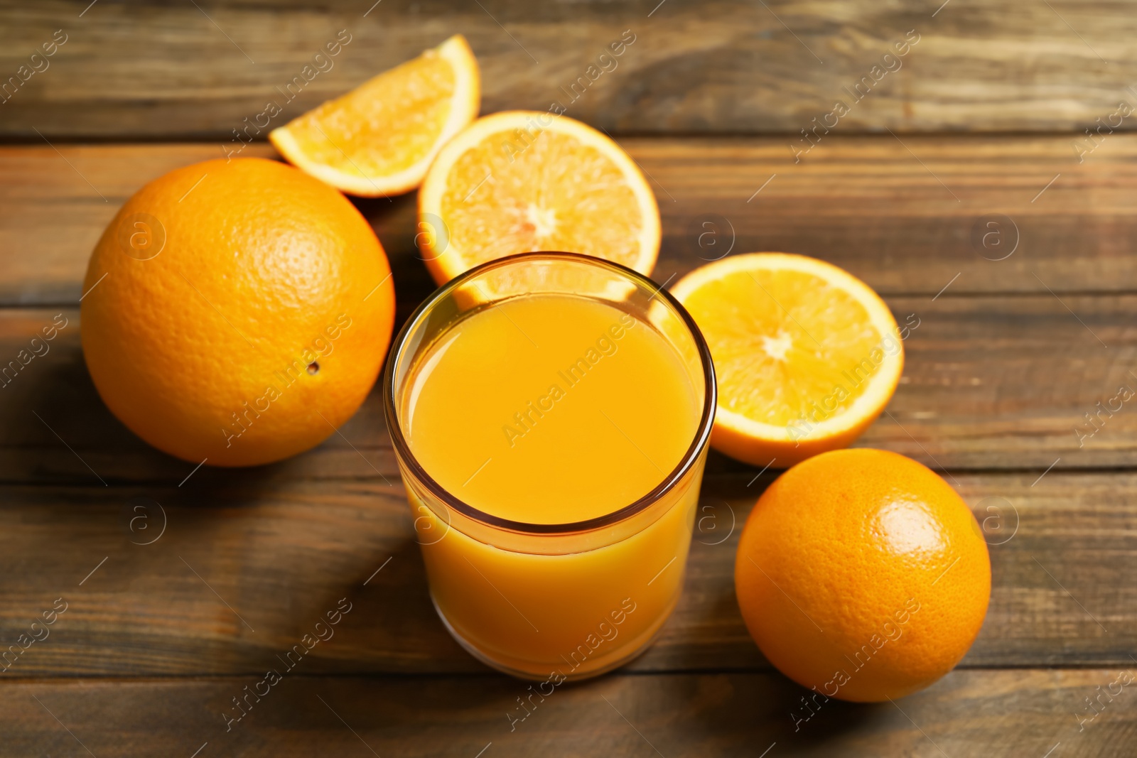 Glass of orange juice and fresh fruits on wooden background Photo of Glass of orange juice and fresh fruits on wooden background