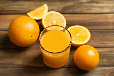 Glass of orange juice and fresh fruits on wooden background Photo of Glass of orange juice and fresh fruits on wooden background
