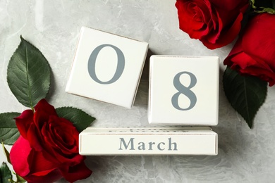 Block calendar with date 8th of March and roses on light grey marble background, flat lay. International Women's Day Photo of Block calendar with date 8th of March and roses on light grey marble background, flat lay. International Women's Day