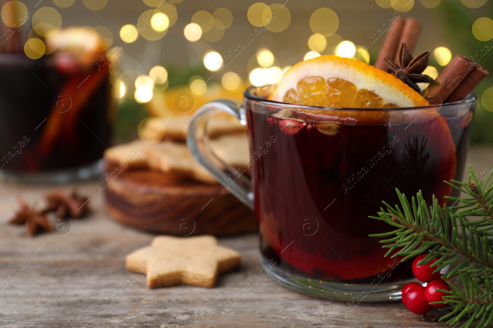 Photo of Aromatic mulled wine on wooden table, closeup. Space for text