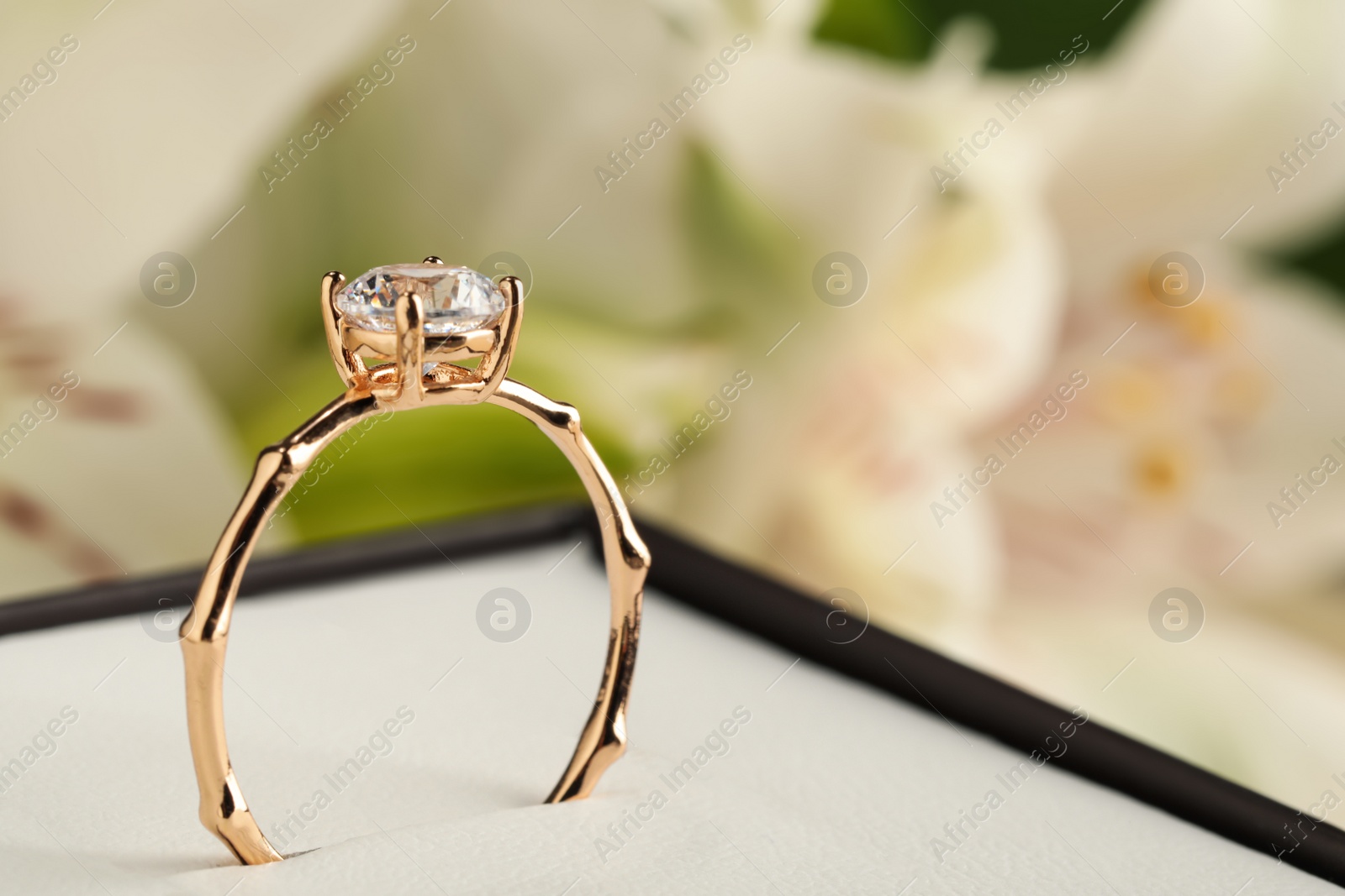 Beautiful engagement ring in box against blurred background, closeup. Space for text Photo of Beautiful engagement ring in box against blurred background, closeup. Space for text