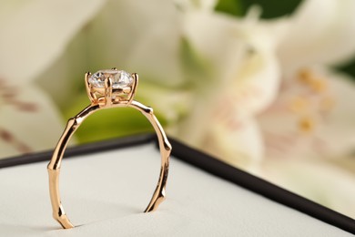 Beautiful engagement ring in box against blurred background, closeup. Space for text Photo of Beautiful engagement ring in box against blurred background, closeup. Space for text