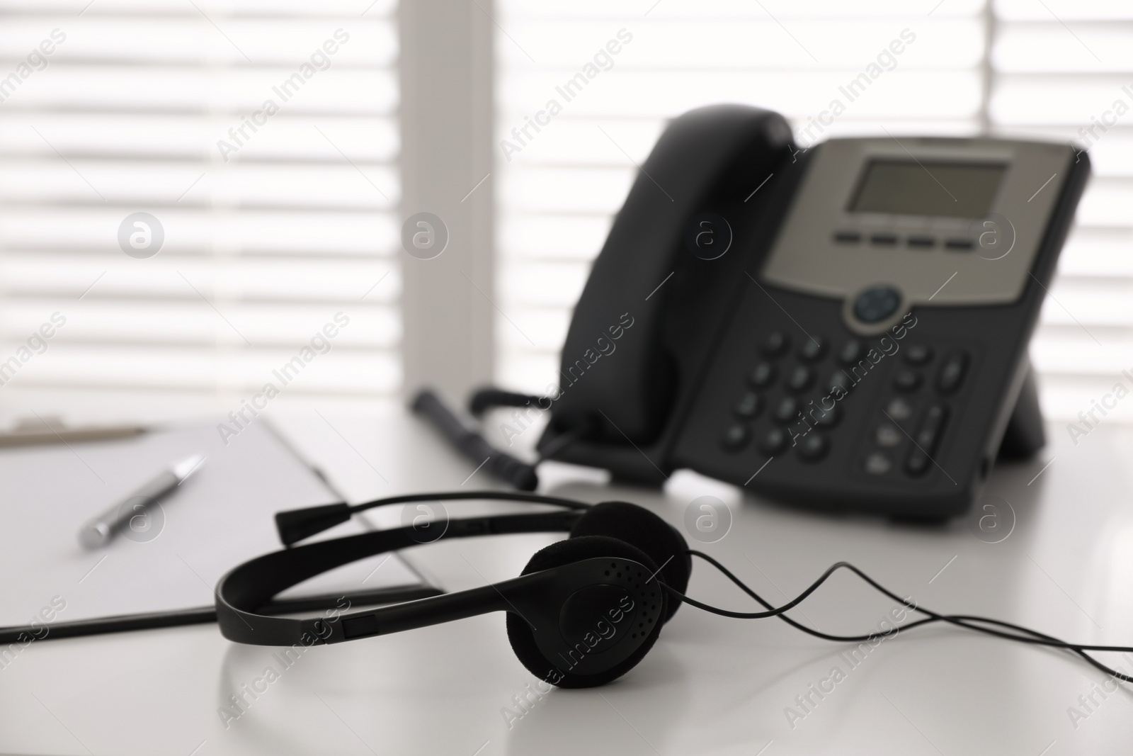 Headset on white table in office, space for text. Hotline service Photo of Headset on white table in office, space for text. Hotline service