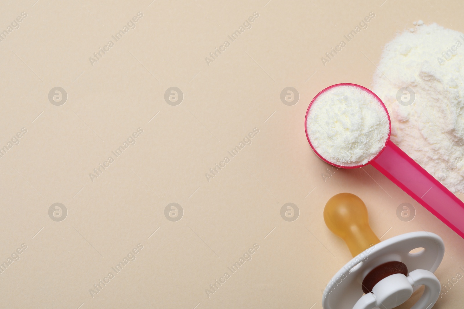 Flat lay of powdered infant formula with scoop and pacifier on beige background, space for text. Baby milk Photo of Flat lay of powdered infant formula with scoop and pacifier on beige background, space for text. Baby milk