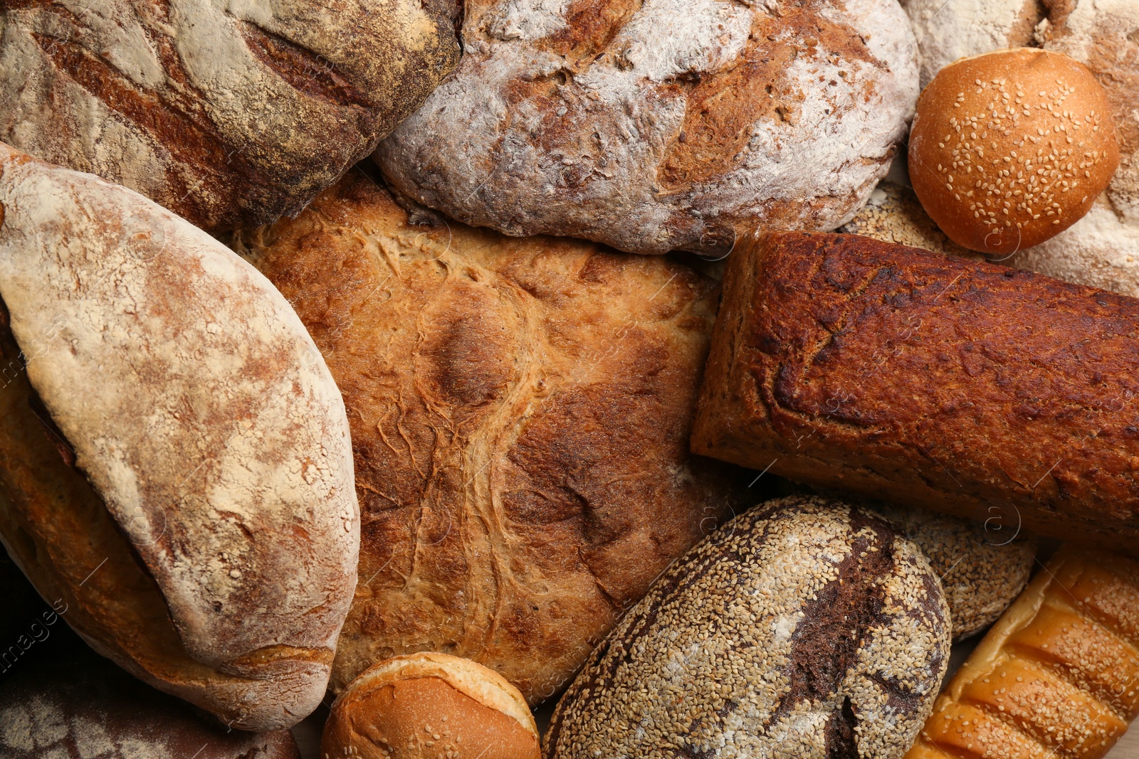 Different kinds of delicious bread as background, top view Photo of Different kinds of delicious bread as background, top view