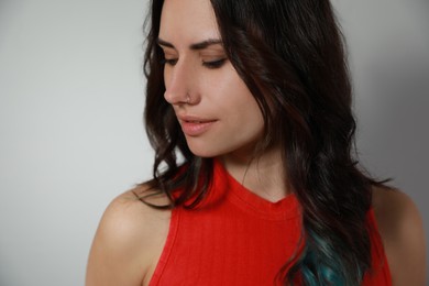 Young woman with nose piercing on grey background, closeup Photo of Young woman with nose piercing on grey background, closeup