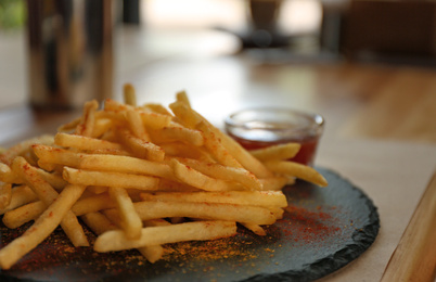 Delicious hot french fries with red sauce served on table Photo of Delicious hot french fries with red sauce served on table