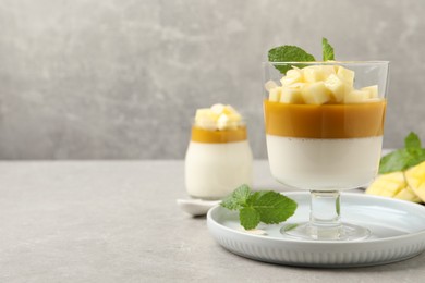 Delicious panna cotta with mango on grey table. Space for text Photo of Delicious panna cotta with mango on grey table. Space for text