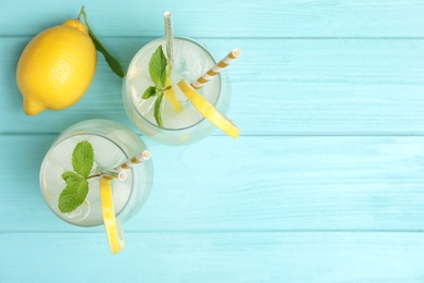 Natural lemonade with mint on light blue wooden table, flat lay and space for text. Summer refreshing drink Photo of Natural lemonade with mint on light blue wooden table, flat lay and space for text. Summer refreshing drink