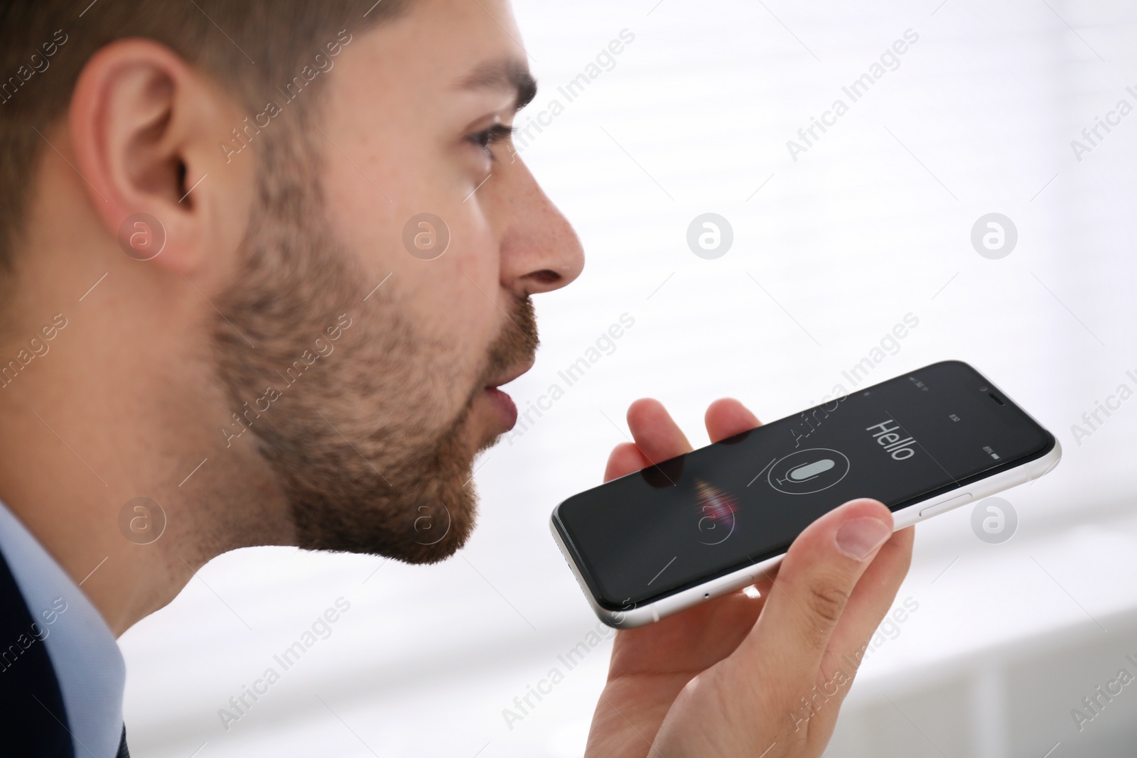 Young man using voice search on smartphone indoors, closeup Photo of Young man using voice search on smartphone indoors, closeup