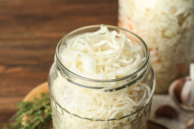 Jar of tasty fermented cabbage on table, closeup Photo of Jar of tasty fermented cabbage on table, closeup