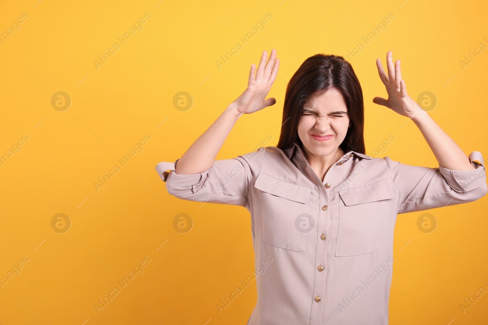 Portrait of stressed young woman on yellow background. Space for text Photo of Portrait of stressed young woman on yellow background. Space for text