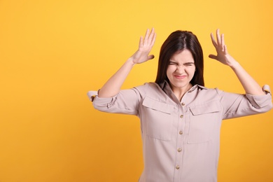 Portrait of stressed young woman on yellow background. Space for text Photo of Portrait of stressed young woman on yellow background. Space for text