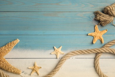 Beautiful sea stars, rope and sand on light blue wooden background, flat lay. Space for text Photo of Beautiful sea stars, rope and sand on light blue wooden background, flat lay. Space for text