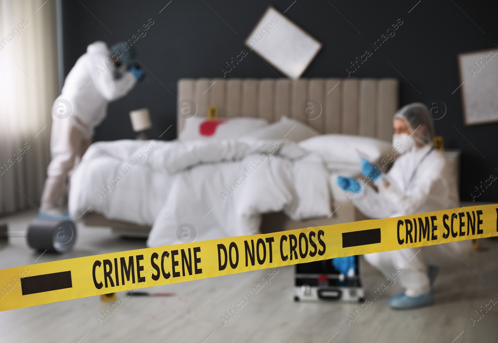 Investigators working at crime scene in messy room, focus on yellow tape Photo of Investigators working at crime scene in messy room, focus on yellow tape