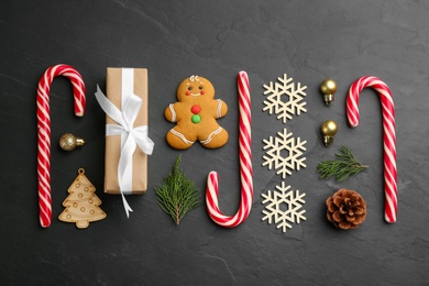 Photo of Flat lay composition with candy canes and Christmas decor on black table