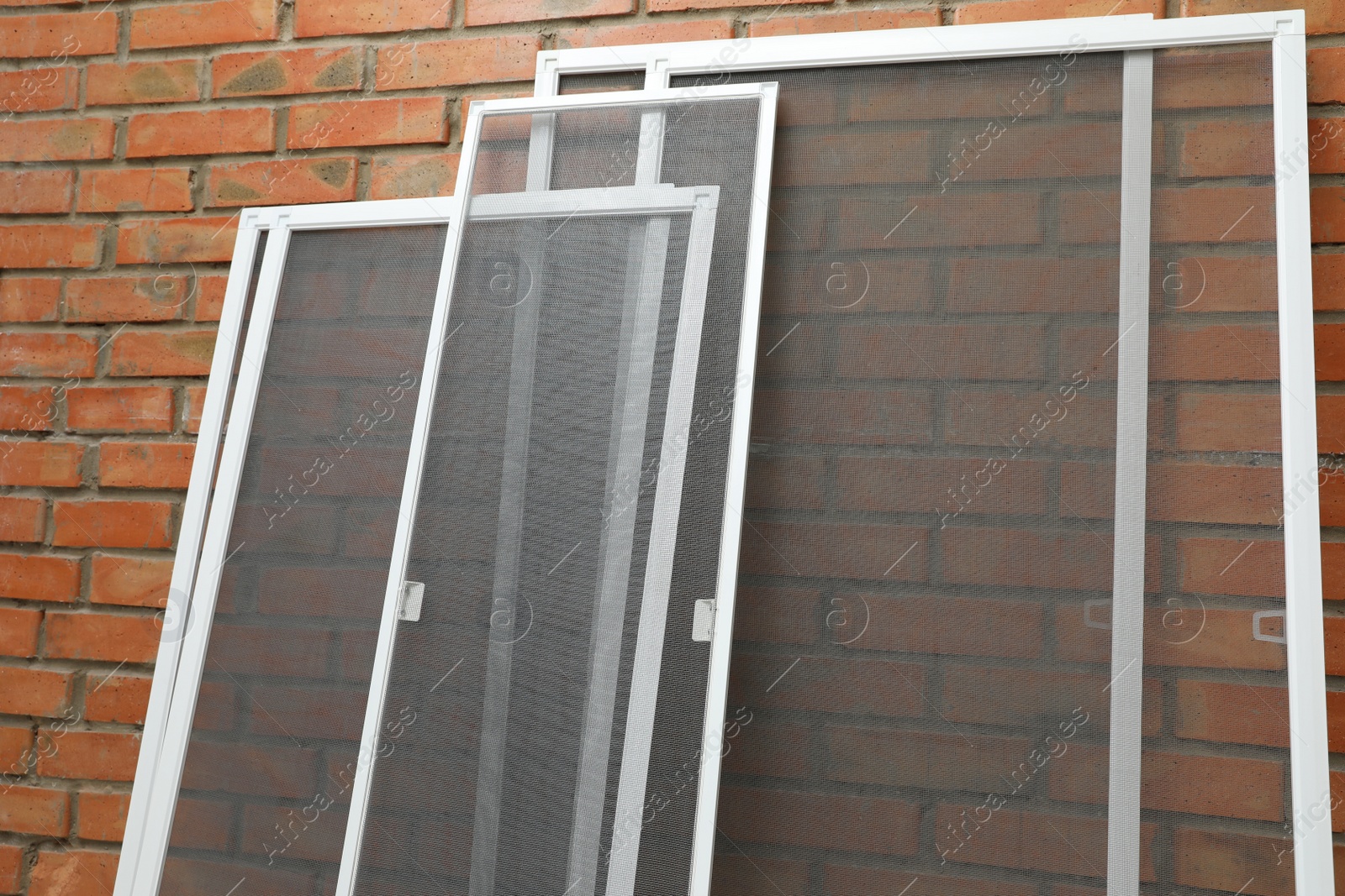 Set of window screens near brick wall Photo of Set of window screens near brick wall