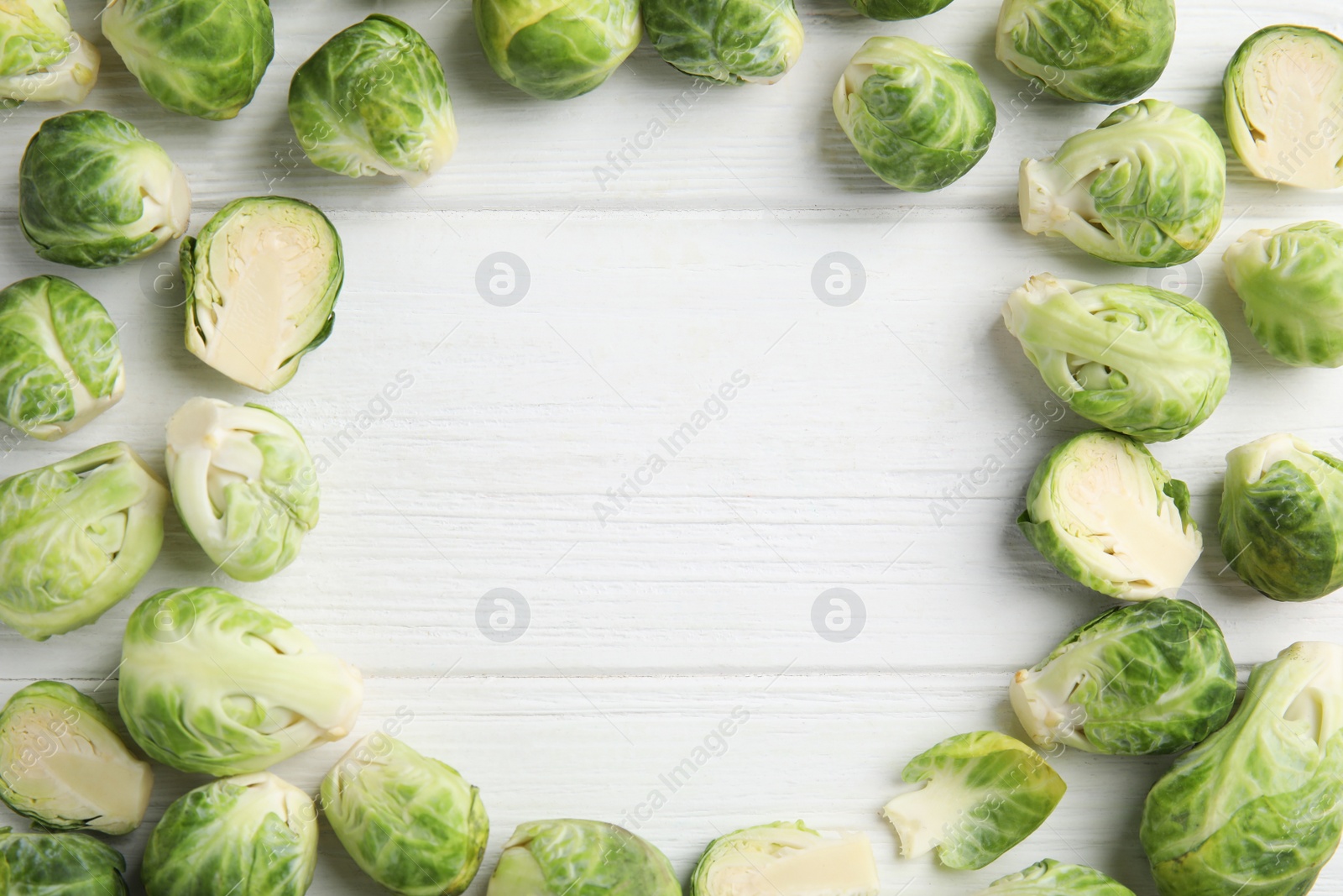 Frame made with fresh Brussels sprouts on white wooden table, flat lay. Space for text Photo of Frame made with fresh Brussels sprouts on white wooden table, flat lay. Space for text
