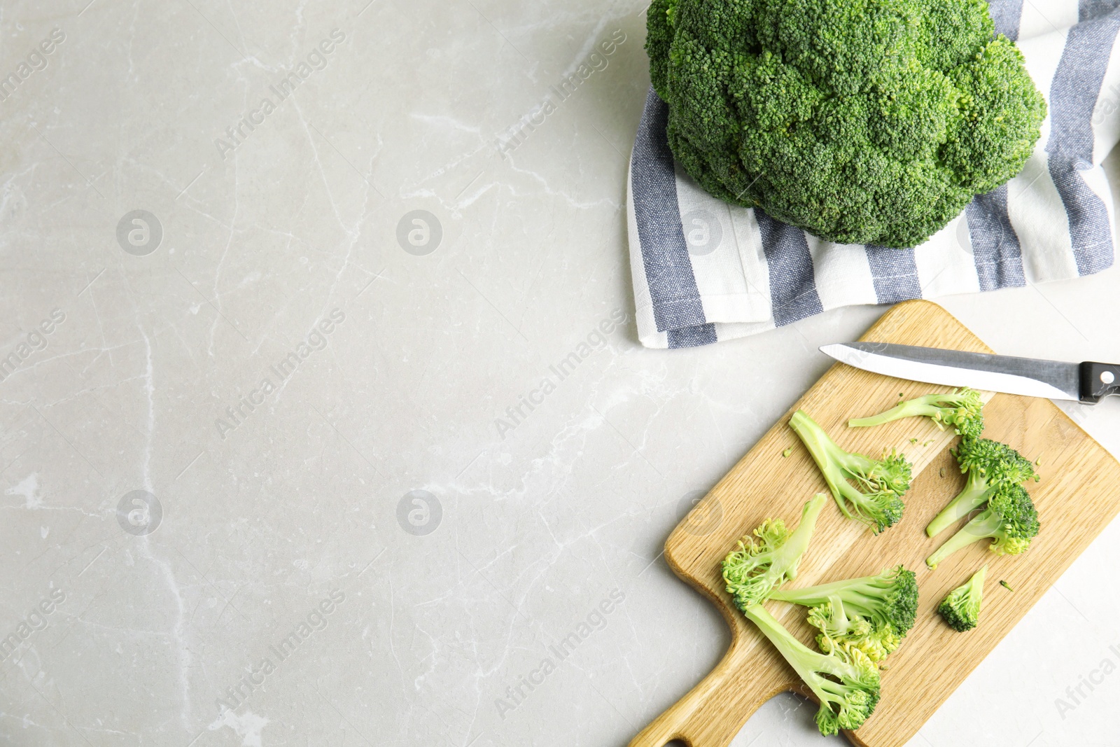 Raw green broccoli on light grey marble table, flat lay. Space for text Photo of Raw green broccoli on light grey marble table, flat lay. Space for text