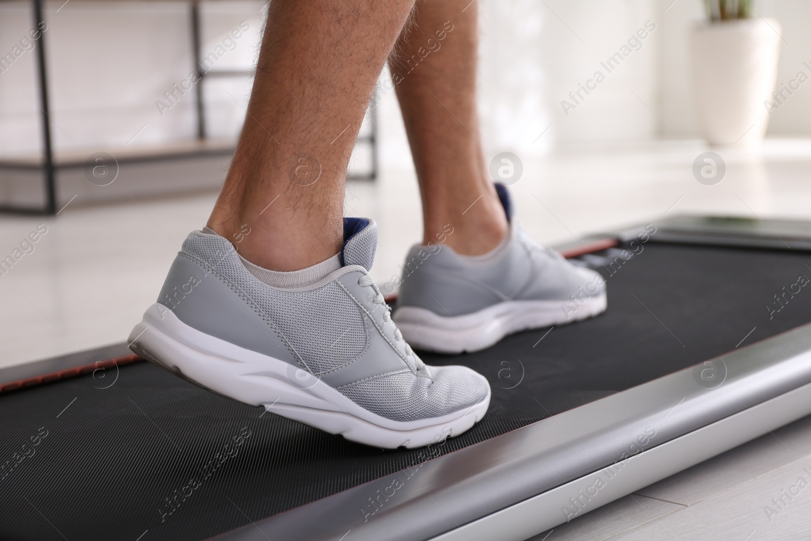 Man training on walking treadmill at home, closeup Photo of Man training on walking treadmill at home, closeup