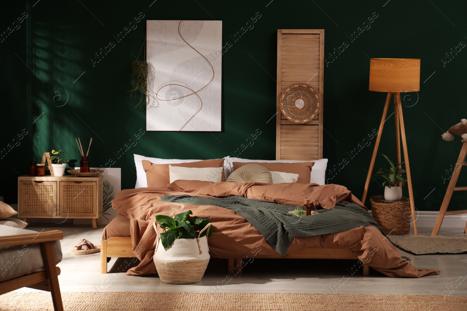 Stylish interior with large comfortable bed and potted plants Photo of Stylish interior with large comfortable bed and potted plants