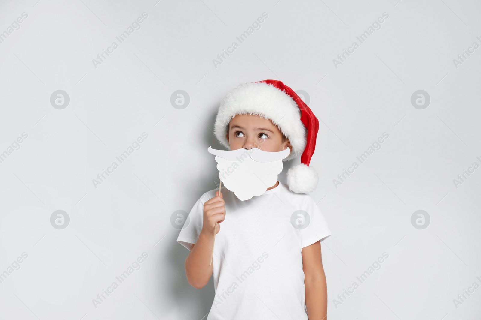 Cute little boy with Santa hat and white beard prop on white background. Christmas celebration Image of Cute little boy with Santa hat and white beard prop on white background. Christmas celebration