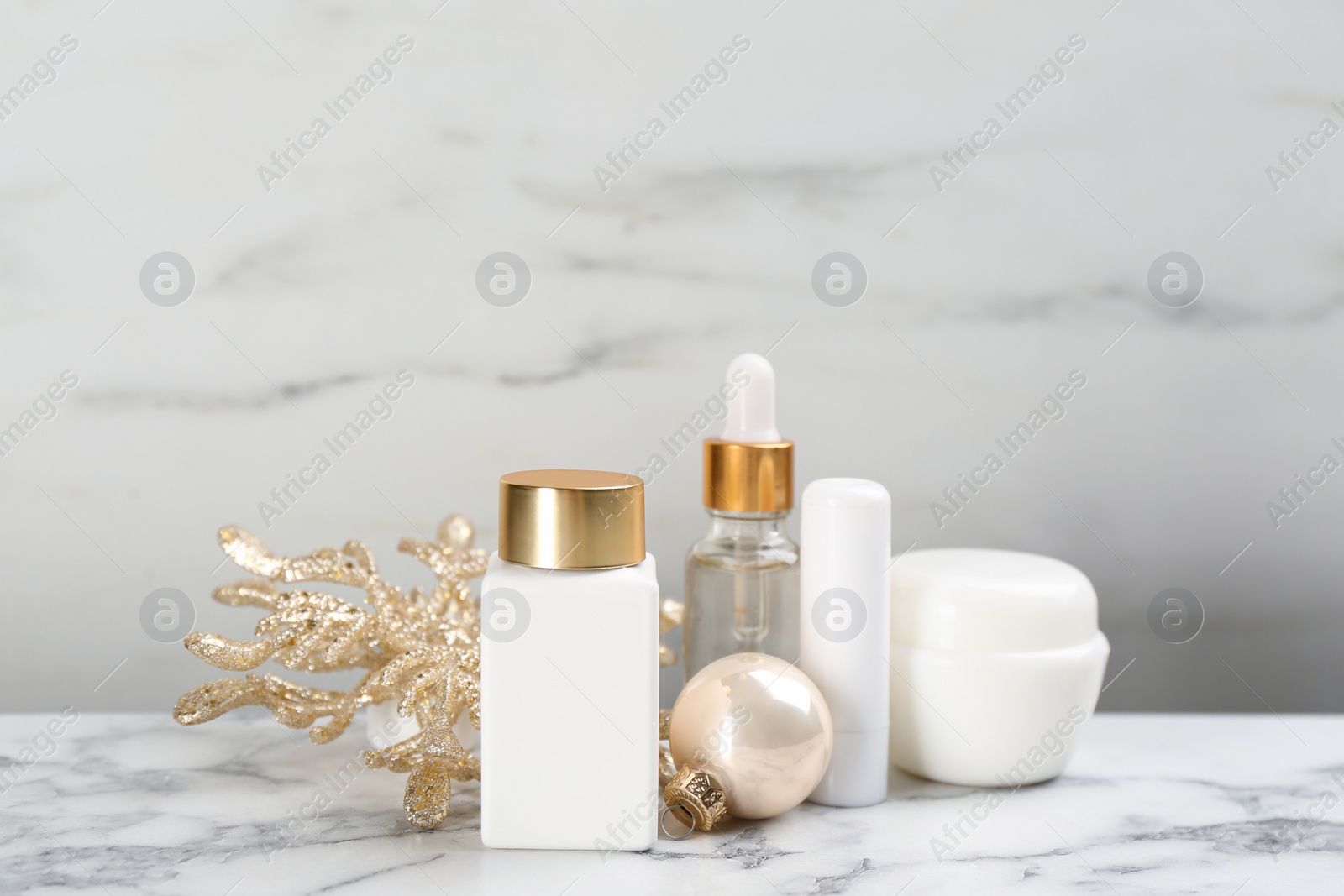 Beautiful composition with cosmetic products on white marble table. Winter care Photo of Beautiful composition with cosmetic products on white marble table. Winter care