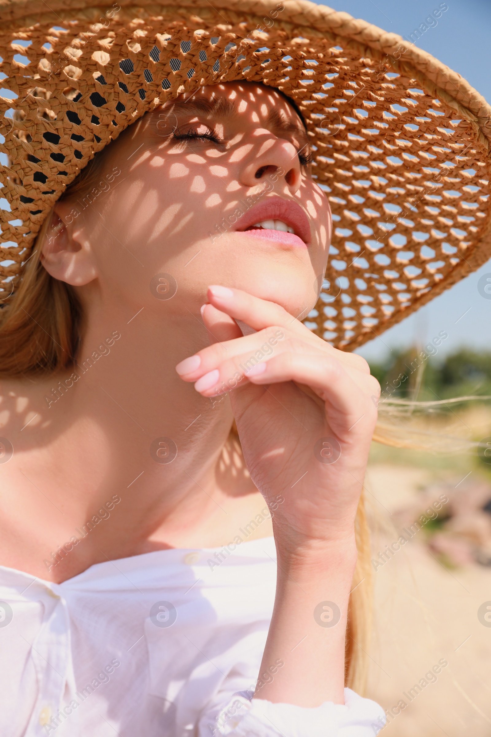 Beautiful woman with straw hat outdoors on sunny day Photo of Beautiful woman with straw hat outdoors on sunny day