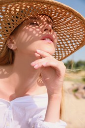 Beautiful woman with straw hat outdoors on sunny day Photo of Beautiful woman with straw hat outdoors on sunny day