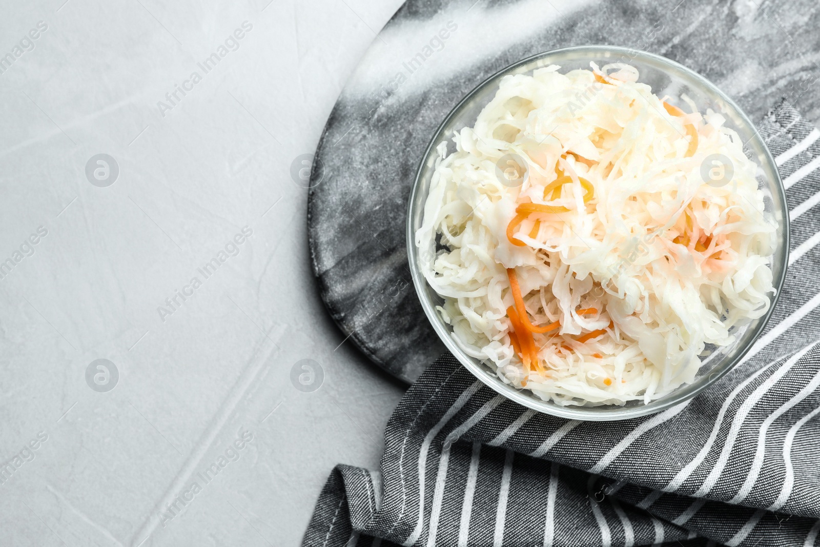 Tasty fermented cabbage on light grey table, top view Photo of Tasty fermented cabbage on light grey table, top view