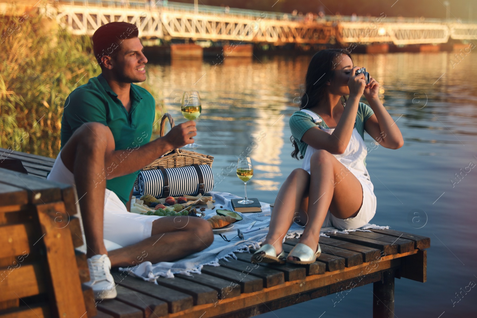 Happy couple spending time on pier at picnic Photo of Happy couple spending time on pier at picnic