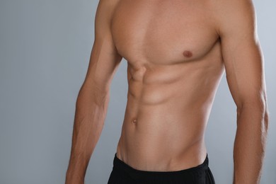 Shirtless man with slim body on grey background, closeup Photo of Shirtless man with slim body on grey background, closeup