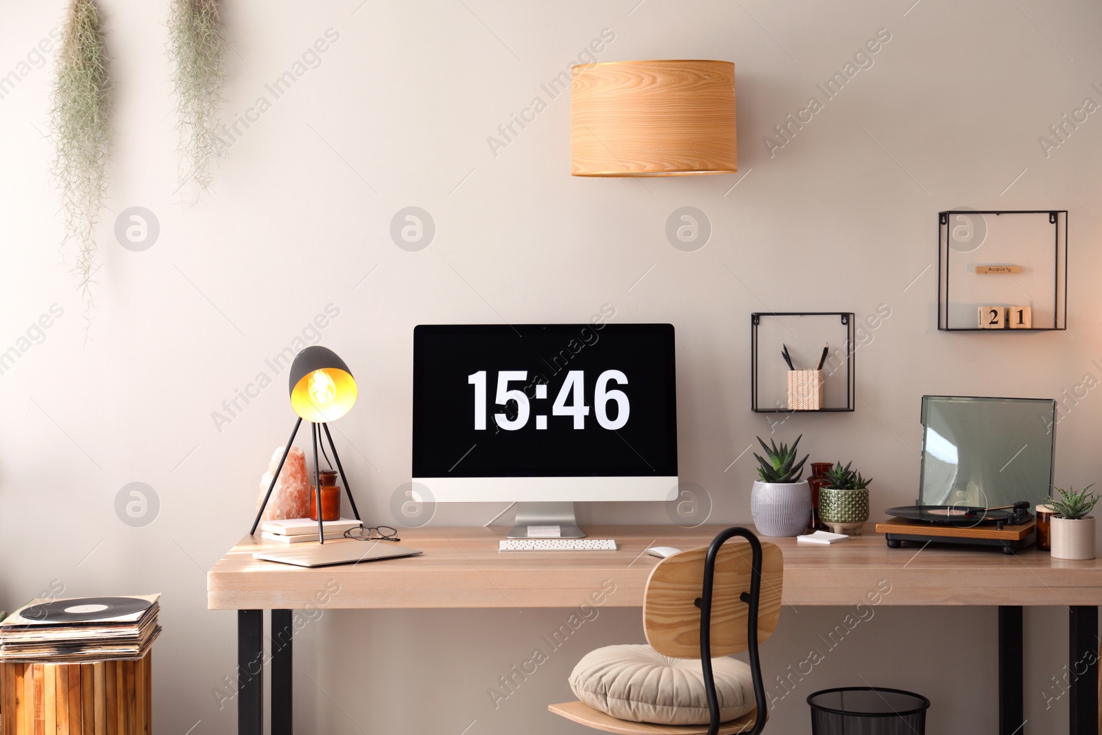 Modern computer and laptop on wooden desk in room. Interior design Photo of Modern computer and laptop on wooden desk in room. Interior design