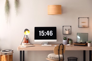 Modern computer and laptop on wooden desk in room. Interior design Photo of Modern computer and laptop on wooden desk in room. Interior design