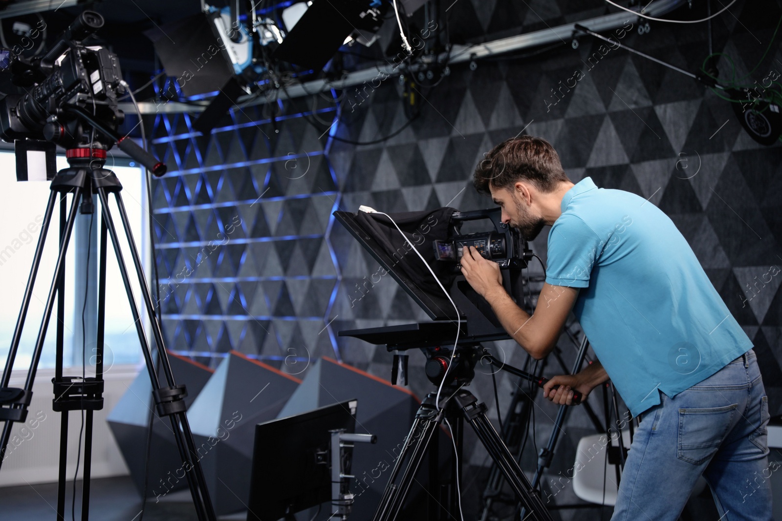 Professional video camera operator working in studio Photo of Professional video camera operator working in studio