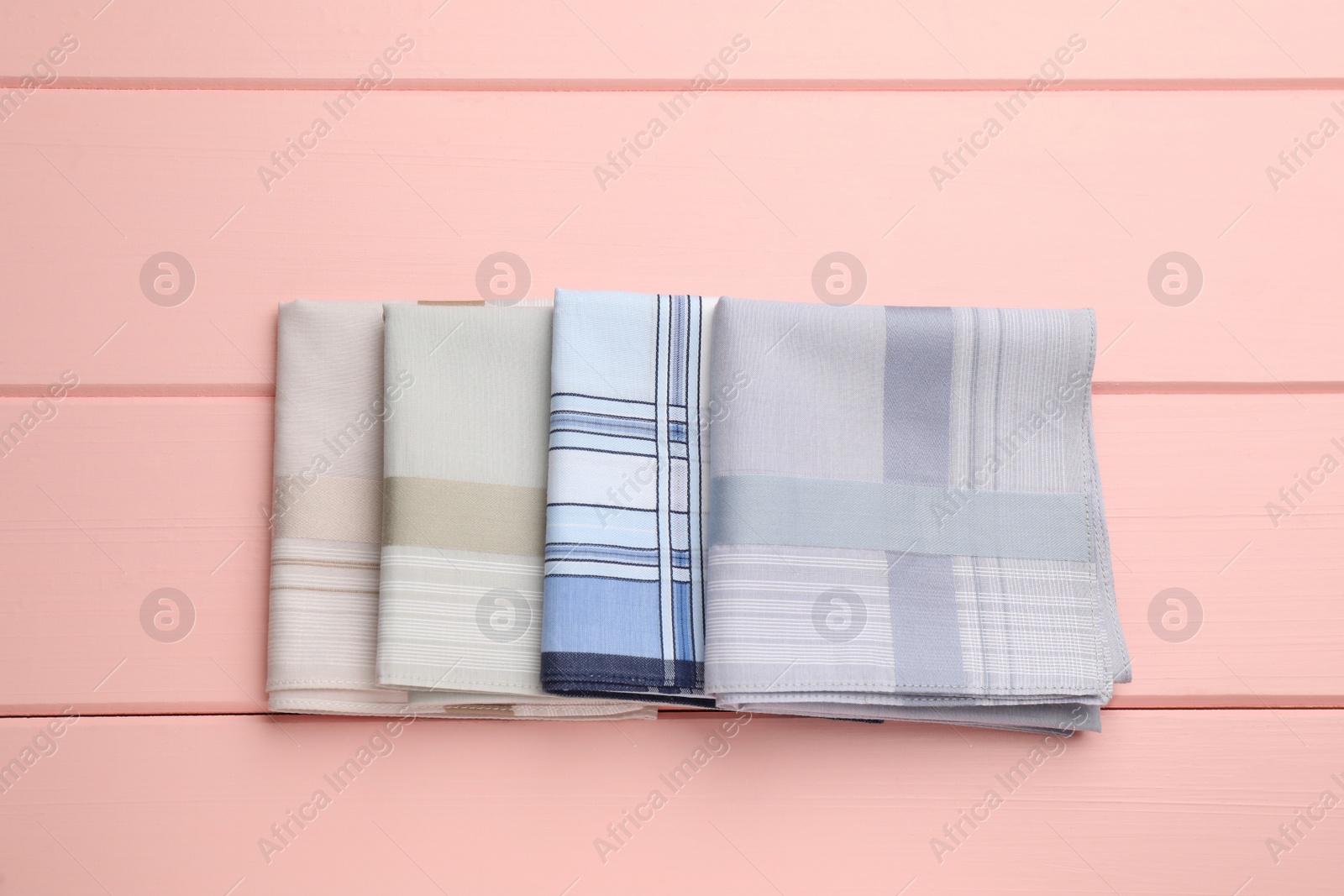 Different handkerchiefs folded on pink wooden table, flat lay Photo of Different handkerchiefs folded on pink wooden table, flat lay